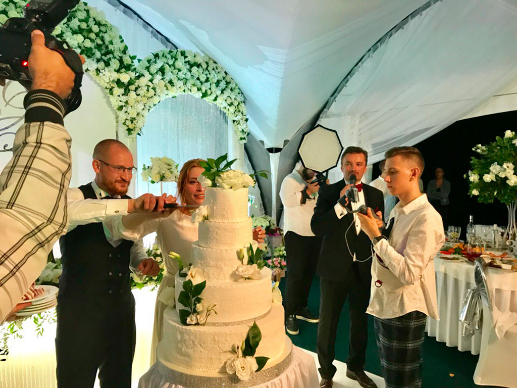 Разрезают торт на свадьбе